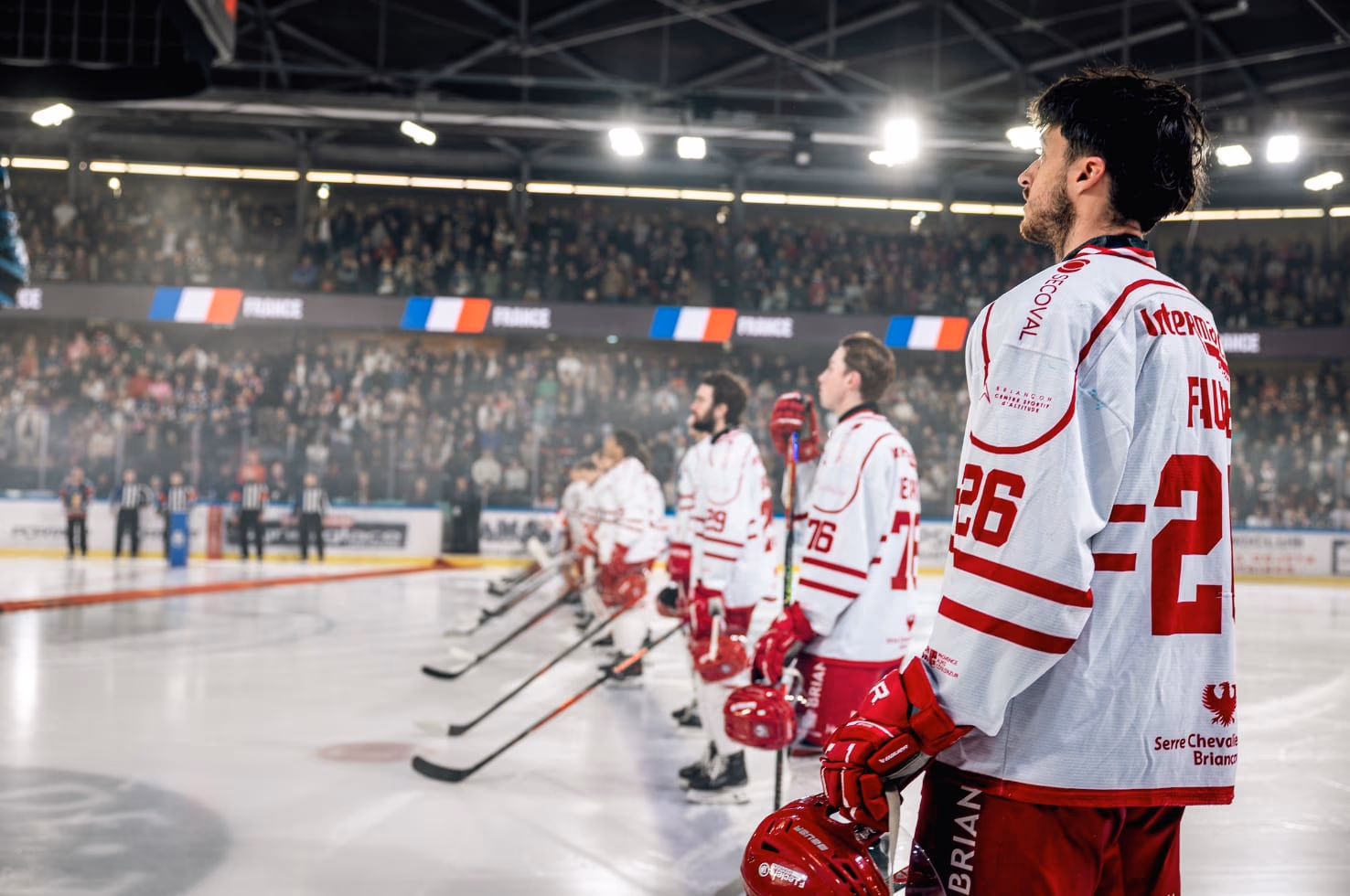 Les joueurs alignés pour l'hymne devant une patinoire René Froger comble